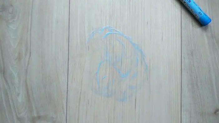 クレヨンのフローリング汚れを歯磨き粉で落としている写真